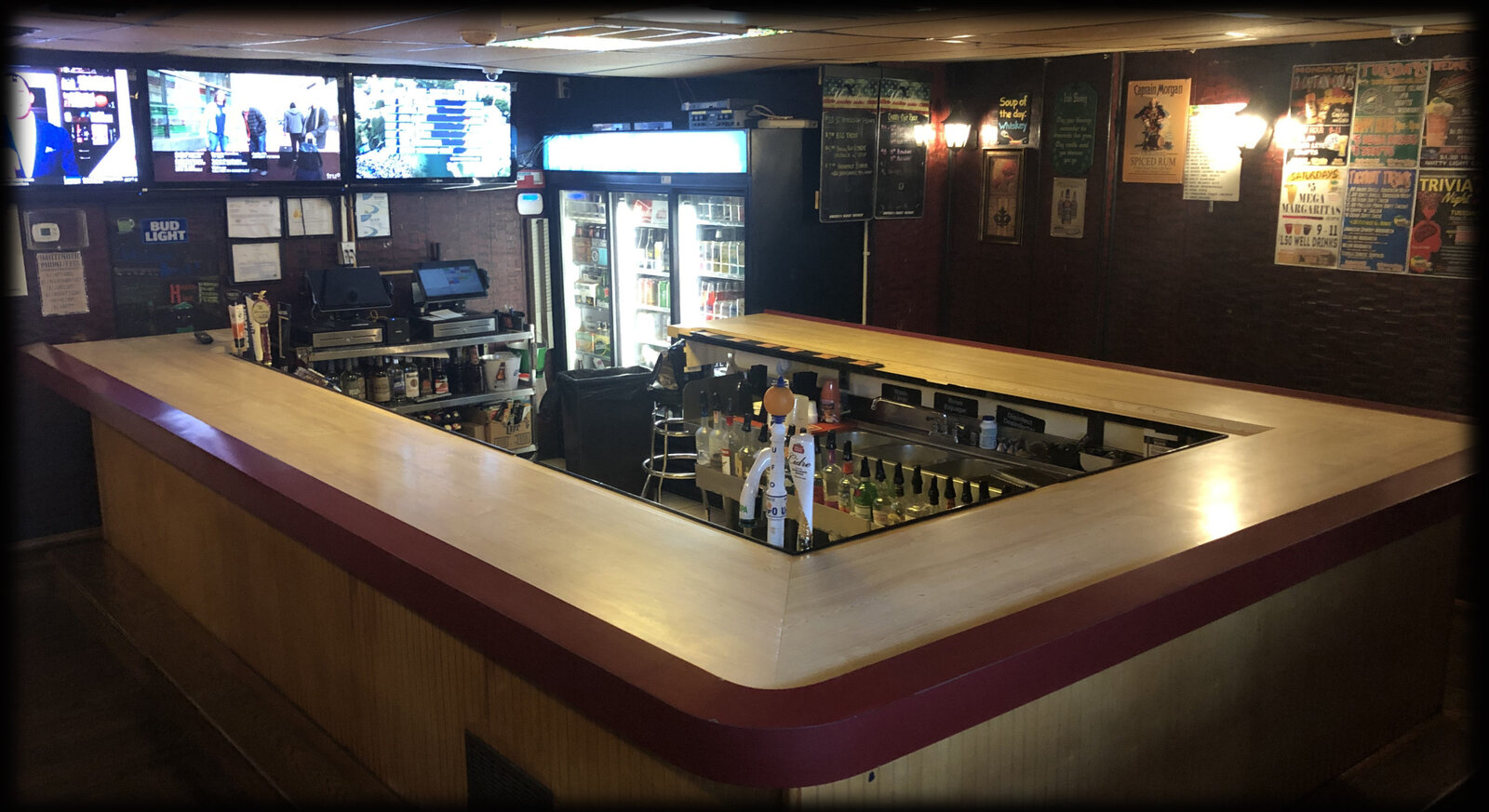 Interior of Murph's Study Hall front bar with stools, TVs, and coolers